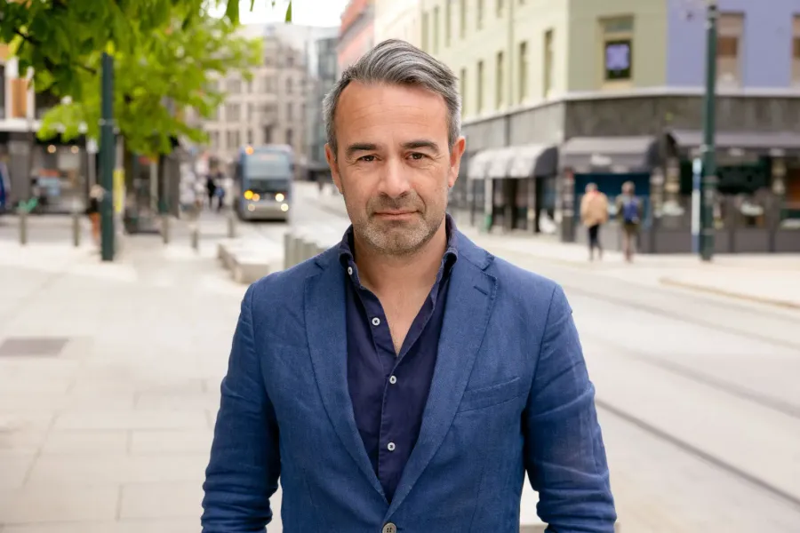 Pressebilde av mann i blå blazer på gate i Oslo