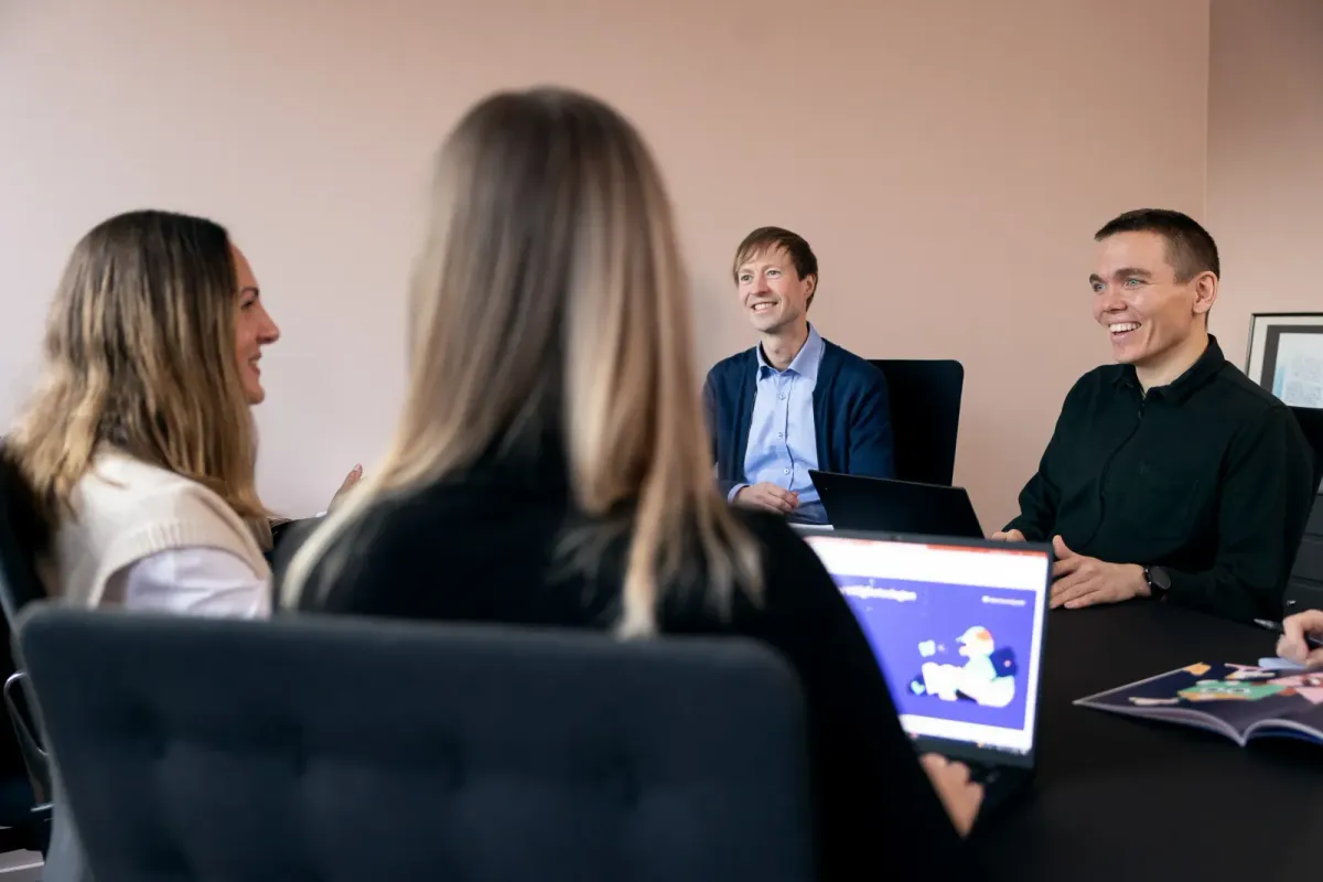 Gruppe i møte rundt bordet med laptop